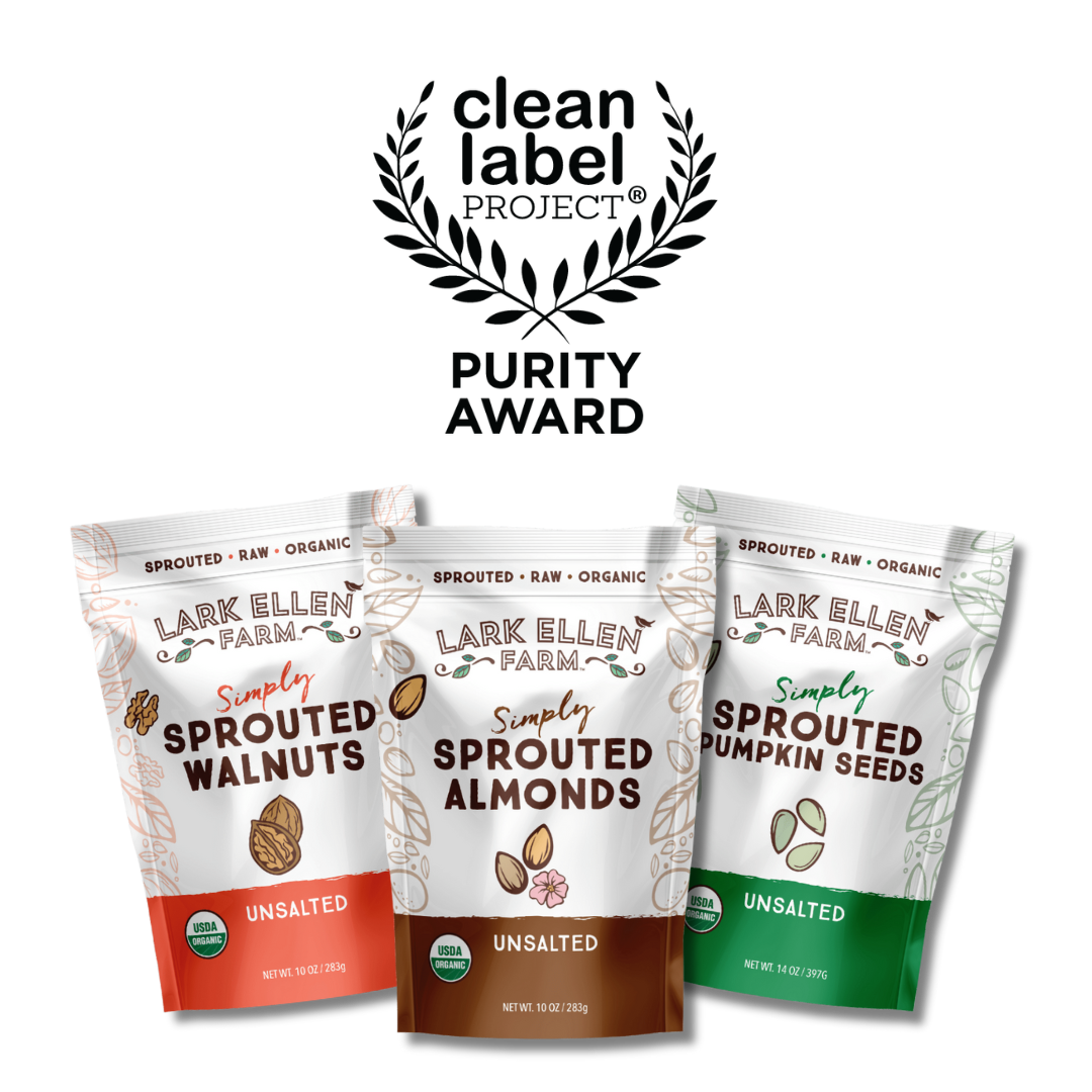 Three Lark Ellen Farm Simply Sprouted bags walnuts almonds and pumpkin seeds before a Purity Award emblem.